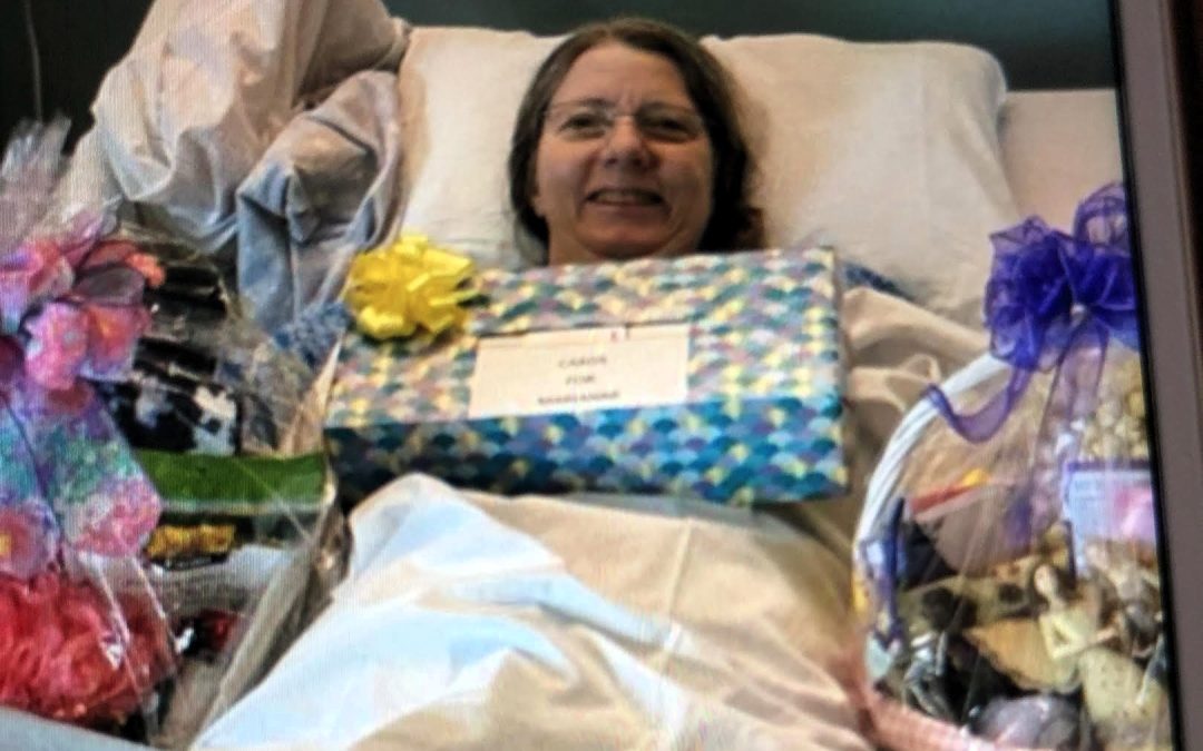 Marianne smiling in hospital bed with presents